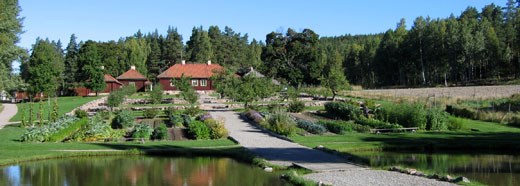 Färgfoto taget i det lokala klonarkivet Kulturreservatet Stabergs bergsmansgård. På fotot ses de olika kvarteren i trädgården.