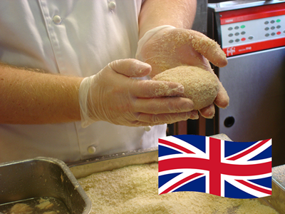 Two hands with plastic gloves rolling food in breadcrumbs