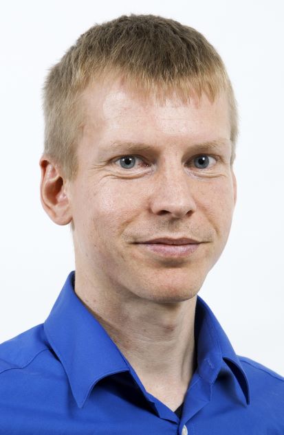 Portrait of a blond man in a blue shirt.