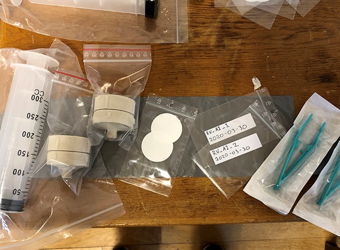 Plastic bottles and other test equipment on table. Photo.