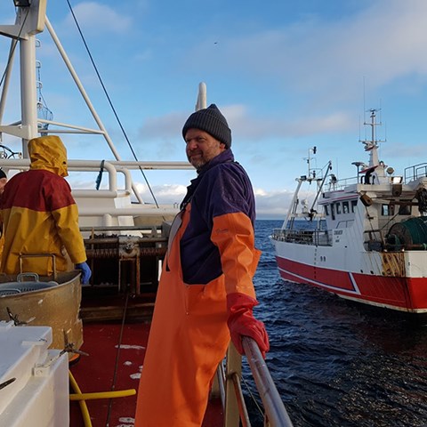 Person står ombord på fiskebåt