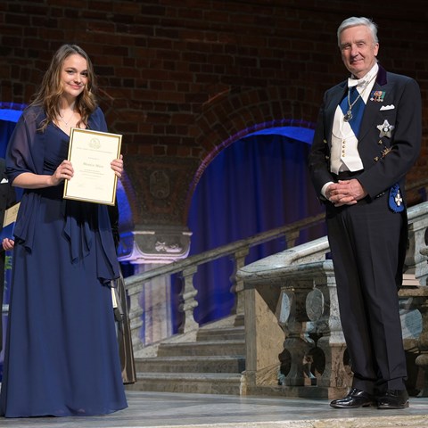 Kvinna  håller upp diplom