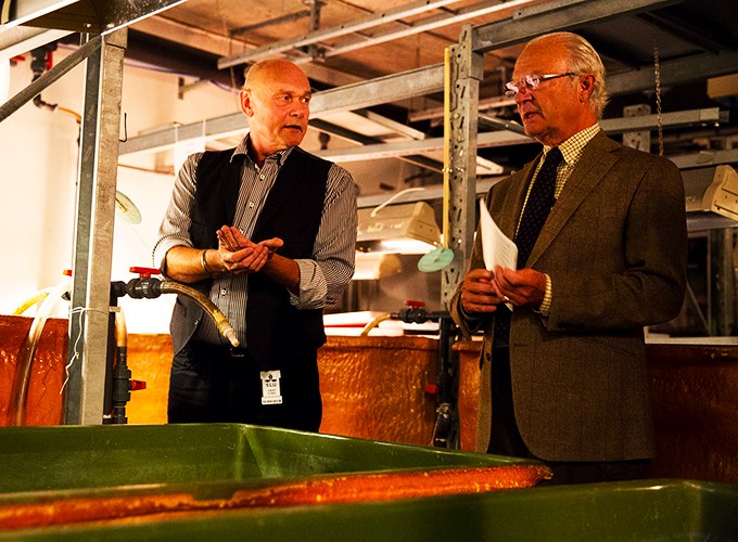 King Carl XVI Gustaf is talking to a researcher. Photo.
