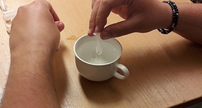 Hand holding a tube.