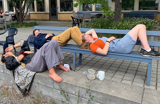 Studenter som ligger ner på en bänk och tar en paus.