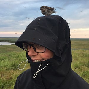 Anna Skarin med liten vild fågel på huvudet. Foto.