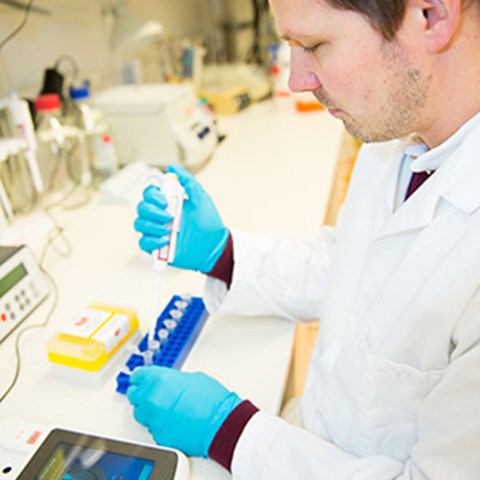 Picture from the page of Johan Dicksved pipetting in a lab. Photo.