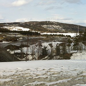 Vintervy över vindkraftspark med några vindkraftverk uppe på ett berg. Foto. 