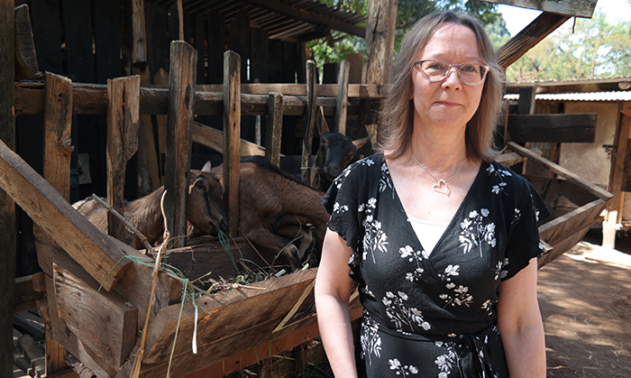 Portrait of Ewa Wredle with goats in the background. Photo.