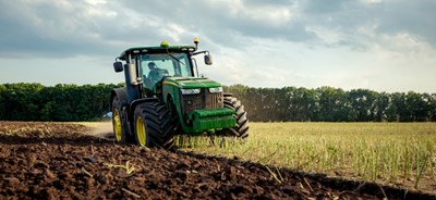 Traktor som bearbetar fält med redskap