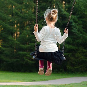 Girl in a swing, in a park