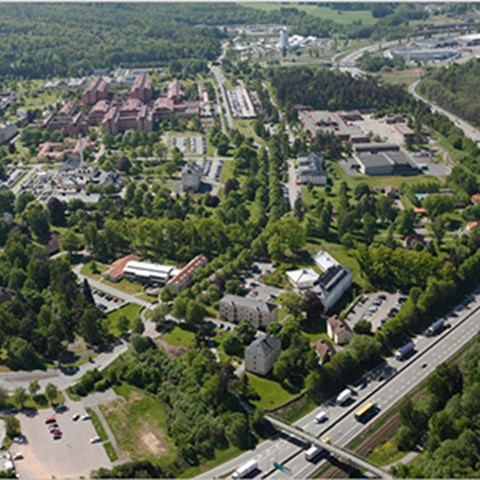 Flygfoto över sjukhusområde med gröna träd och gräsmattor