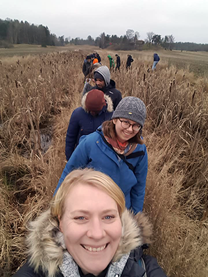 Happy students on a row in a brown field, photo.