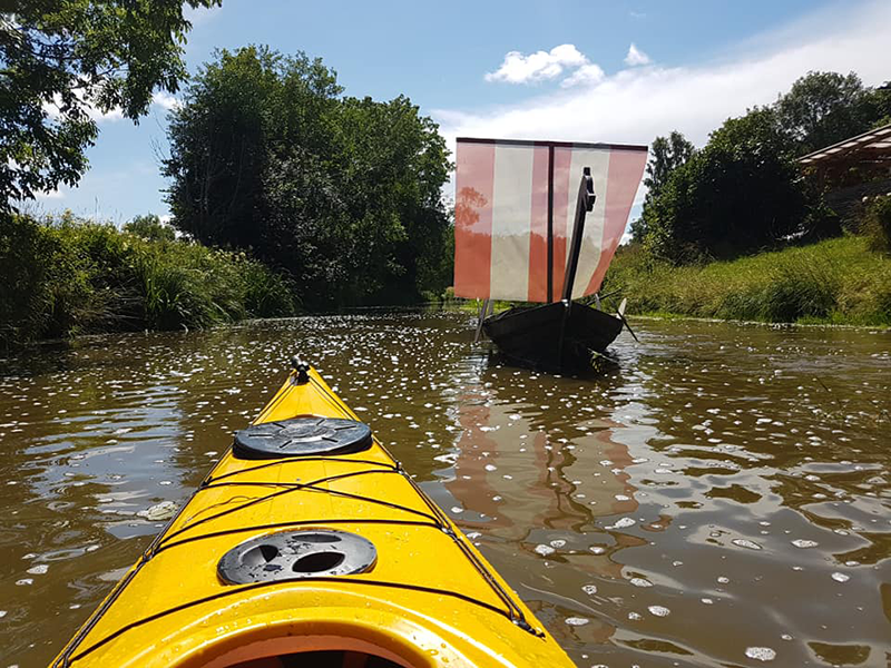 Canoe and a small viking ship on a river, photo.