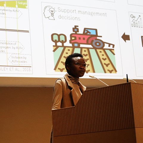 woman at podium in front of a screen