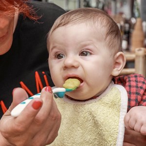 Bebis som äter mat, foto.