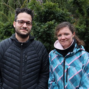 The researchers Tino Colombi and Katharina Meurer outside in front of a pine tree