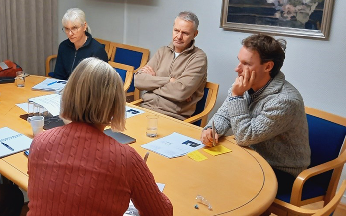 1fyra personer runt ett bord med anteckningsblock.
