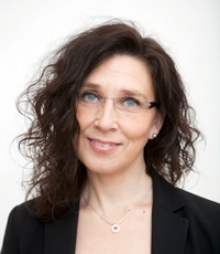 Porträttfoto av en leende kvinna med mörkt hår, foto.