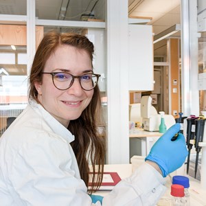 A woman with a pipett in a lab. Photo.