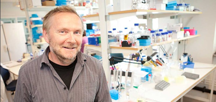 A smiling man in a lab, photo.