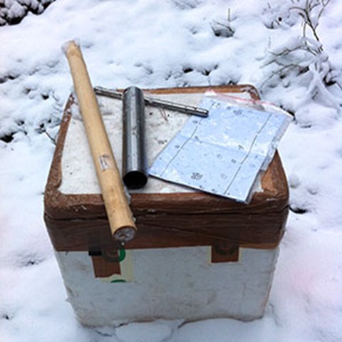A box with tools on it on snowy ground, photo.