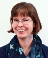 Porträttfoto av leende kvinna.