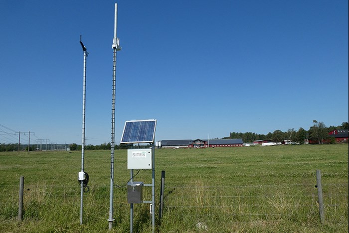 Mast med kamera vid ett fält. Foto.