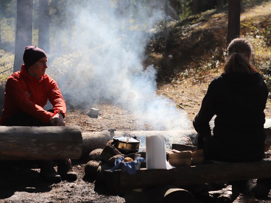Two persons by camp fire