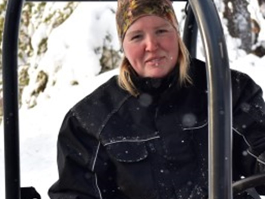 Kvinna sittande i traktor i snölandskap