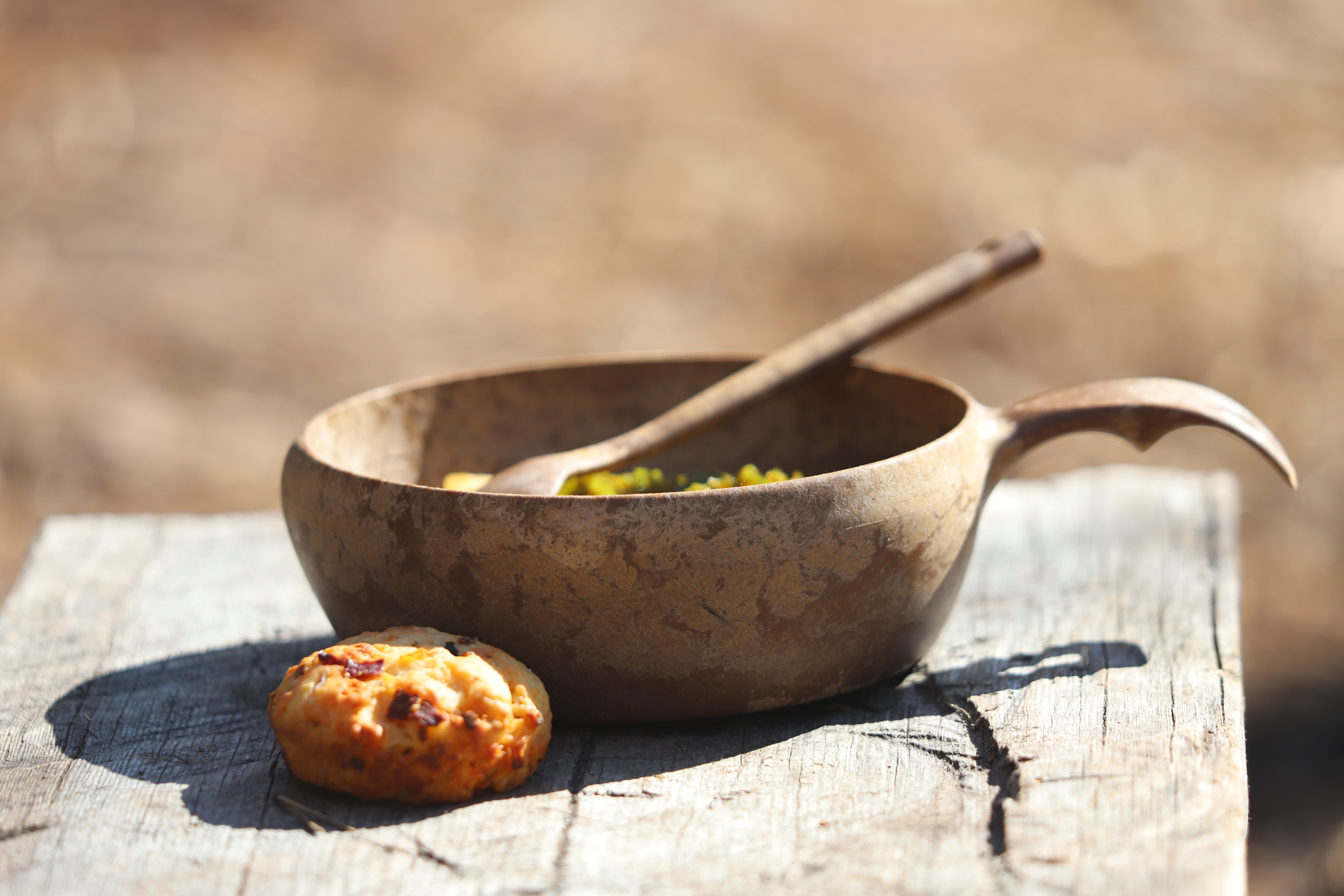 Cup with soup on wooden table outdoors