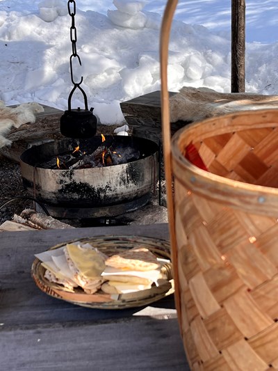 Korg och smörgåsar vid brasa