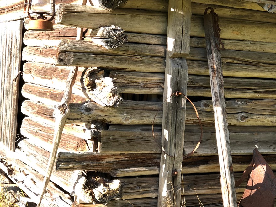 Timbered hut and old fashioned scythe and other tools