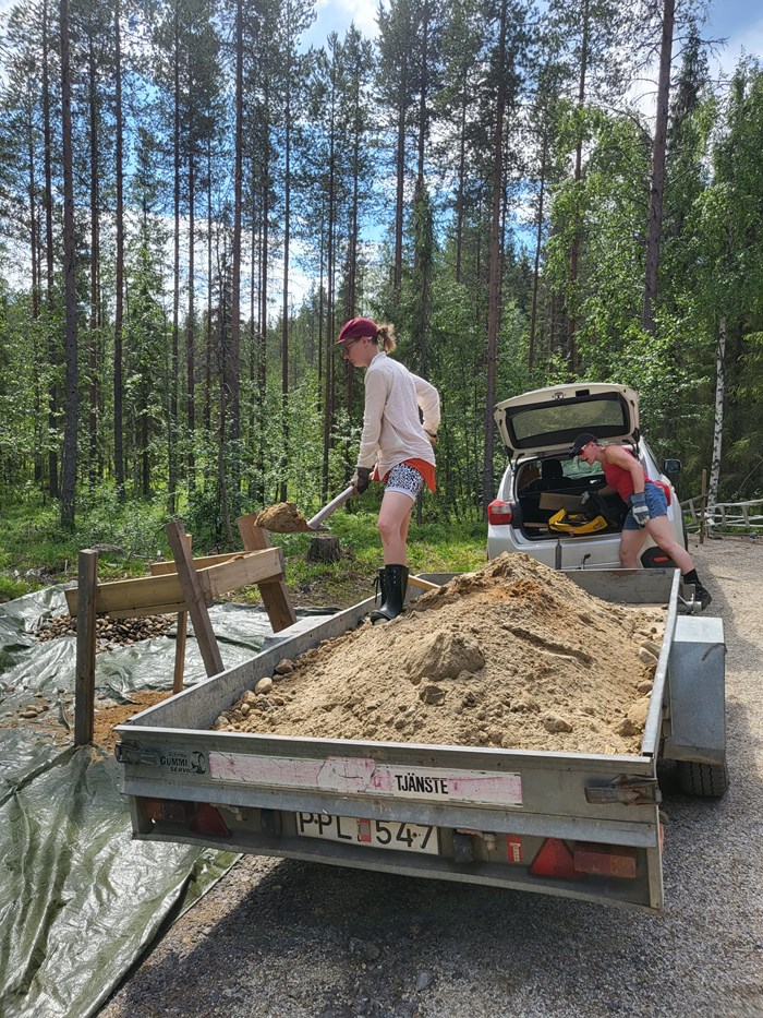 Sand till kanalexperimentet skyfflas ner i testkanalerna.