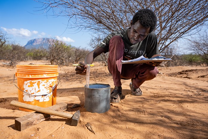 Fältassistent i norra Kenya utför markinfiltrationsmätning.