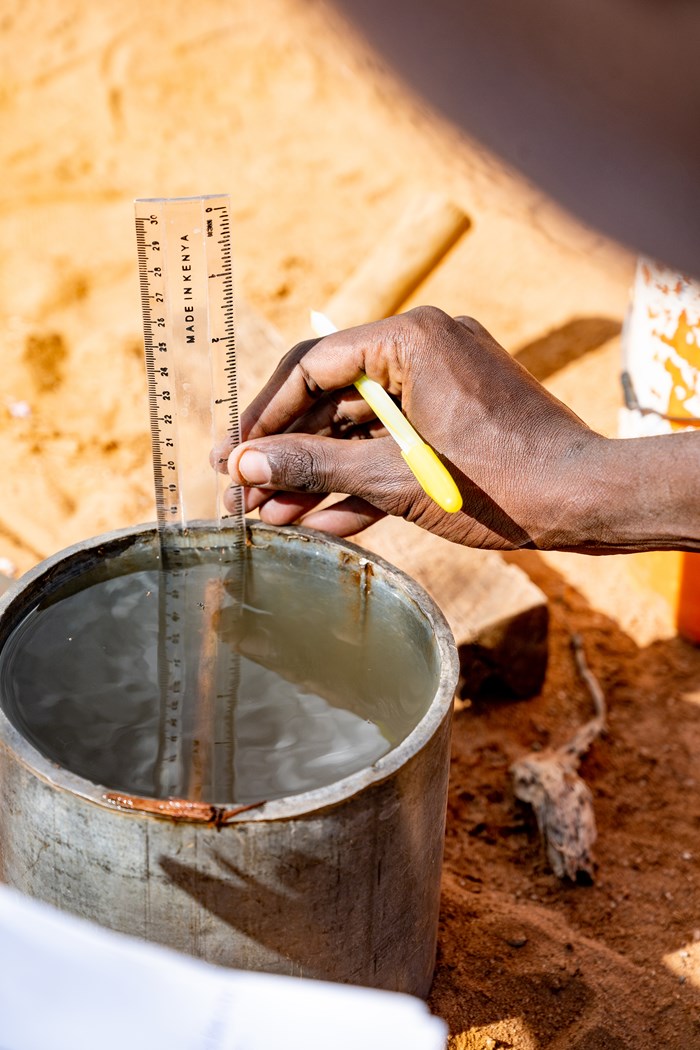 Detail of field assistant in northern Kenya performing infiltration measurement.