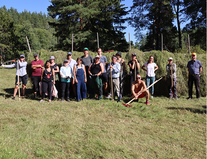 Particiapnts in the summer course, standing in front of the hay rack. Photo.