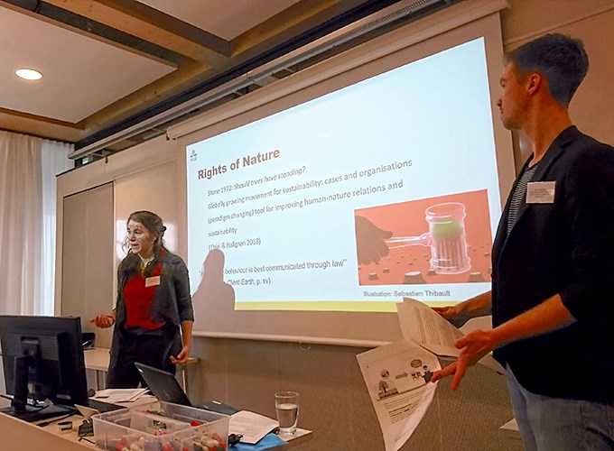 En kvinna framför en projektorduk med orden Rights of Nature på. Foto.