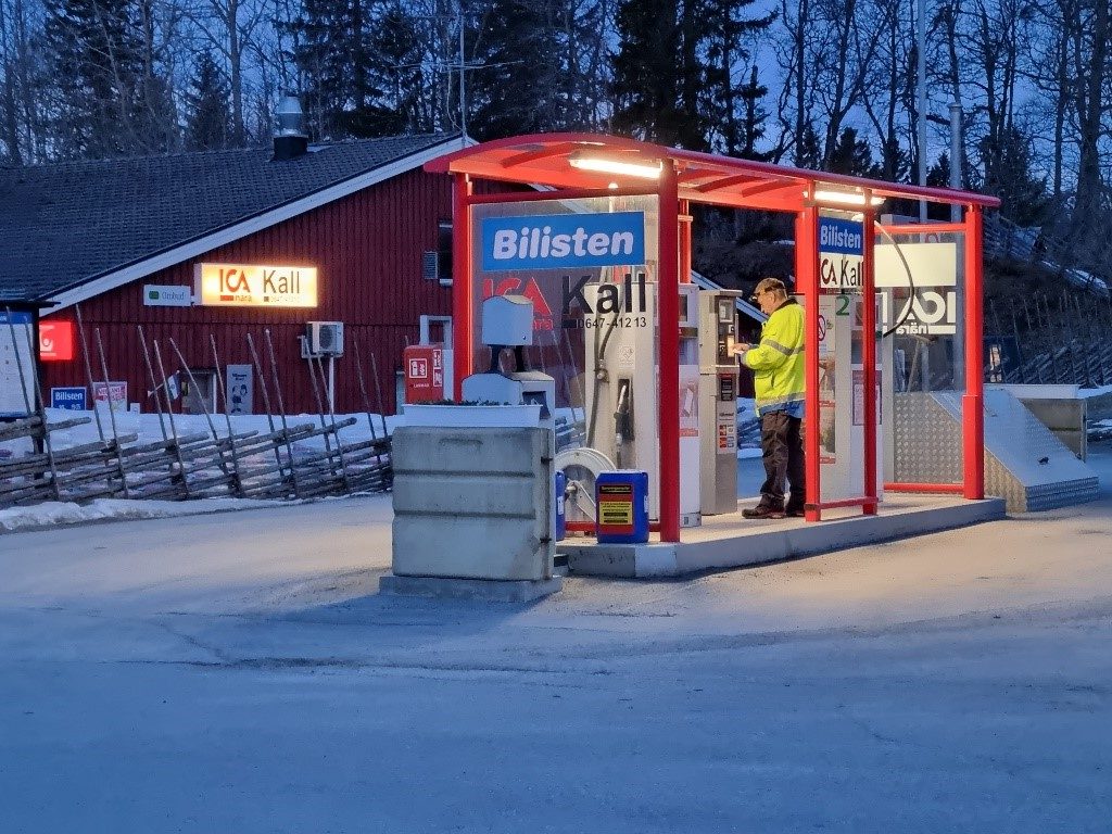 Bensinpumpar utanför en liten matbutik, foto.