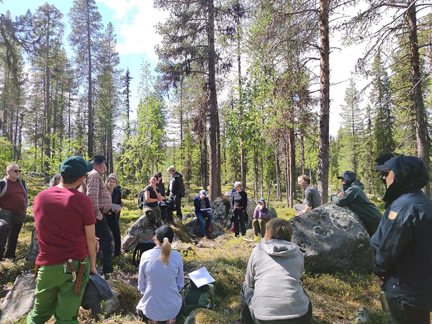 En grupp människor i skogen på exkursion. Foto.
