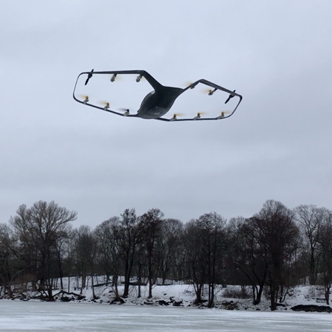 Drönare flyger över skog i vinterlandskap, foto.