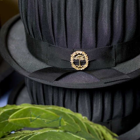 Black hat with forest college emblem. Photo.