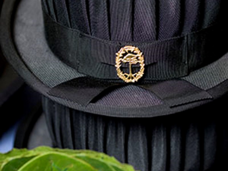 Black hat with forest college emblem. Photo.