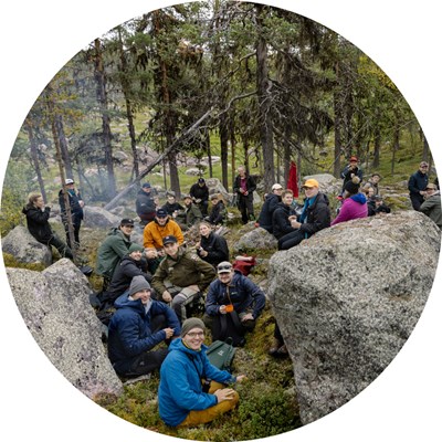 Many happy people sitting in a forest. Photo.