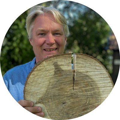 A happy man holds a wooden board. Photo.