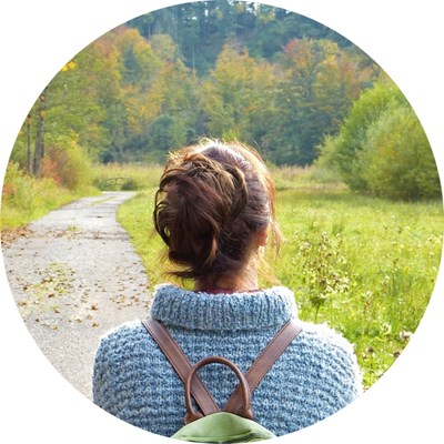 A woman with a back-pack from behind. Photo.