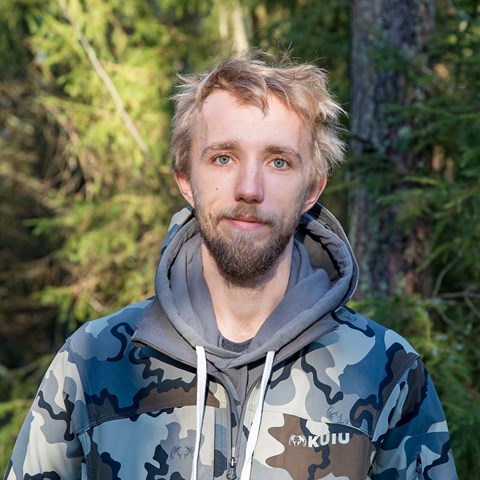 Porträttbild av Lukas Graf i skog.
