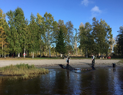 two people fishing with a net in a lake