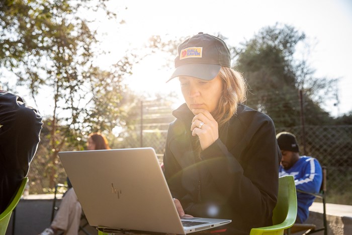 Moa Dahlberg in the sun working on her computer.