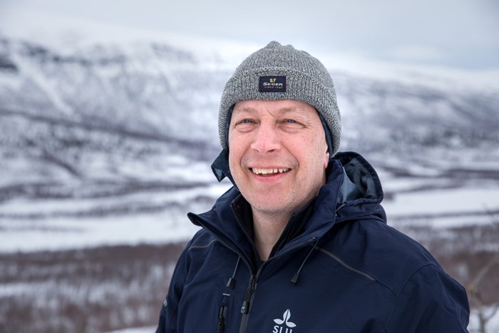 Göran Ericsson i vintermiljö med fjäll i bakgrunden. Foto.